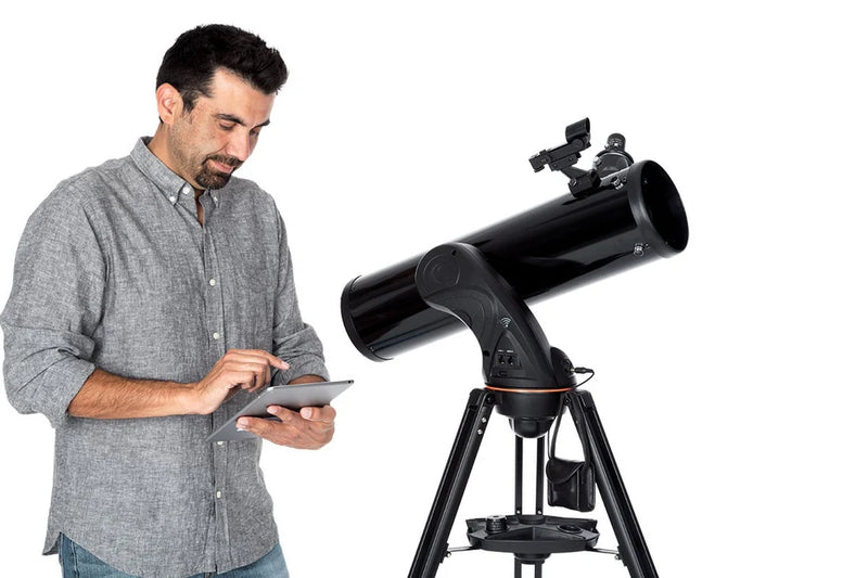 Celestron AstroFi 130 Wi-Fi Newtonian reflector telescope with tripod setup, featuring a sleek black optical tube and control panel.