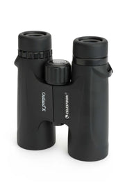 Celestron Outland X 8x42 roof binoculars showing the black body, eyepieces, and adjustable focus in a standing position.